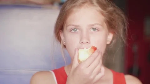 Beautiful caucasian girl looking at camera and eating apple Stock Footage