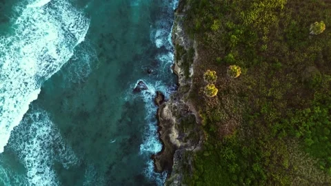 Beautiful cave rocky beach with blue water on sunrise in tropics. Aerial Drone Stock Footage 266853653