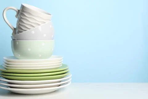 Beautiful ceramic dishware and cup on white table, space for text Stock Photos