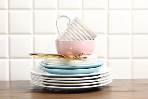 Beautiful ceramic dishware, cup and cutlery on wooden table Stock Photos