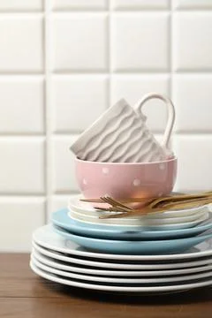 Beautiful ceramic dishware, cup and cutlery on wooden table Stock Photos