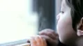 beautiful child bored and sad looking through window HD Footage
