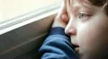 beautiful child bored and sad looking through window HD Footage