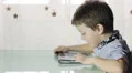 beautiful child uses a tablet and looks at the camera HD Footage