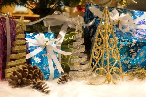 Beautiful Christmas gift boxes on floor near fir tree in room Stock Photos