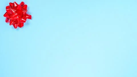 Beautiful Christmas red present ribbon bow over light blue background with sp Stock Photos