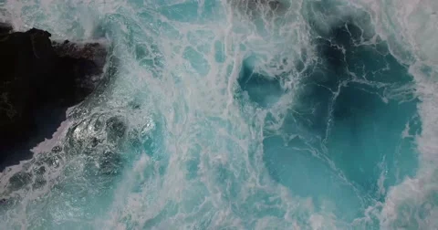 BEAUTIFUL CINEMATIC 4K AERIAL OF DEEP BLUE WAVES CRASHING AGAINST ROCK CLIFF Stock Footage