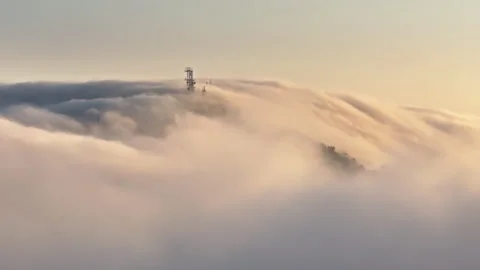 Beautiful cinematic clouds waterfall soaring around Radio tower on mountain peak Video stock 245766251