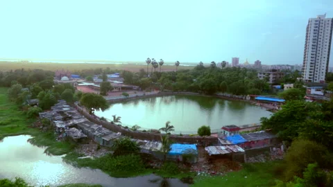 Beautiful Circular Pond Surrounded by Greenery and building during Sunset Stock Footage 139055214