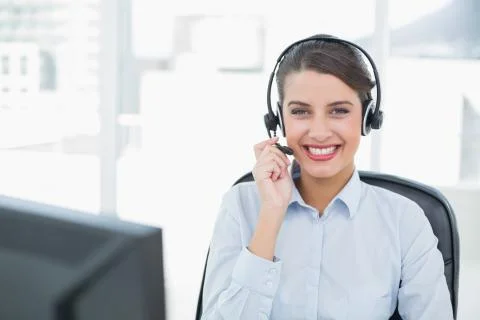Beautiful classy brown haired operator answering a call Stock Photos