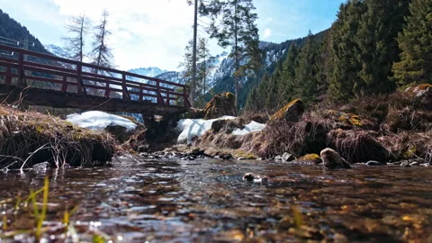 Beautiful Clear Stream Flowing Under Bridge in the Scenic Swiss Alps Vídeos de archivo 334103142
