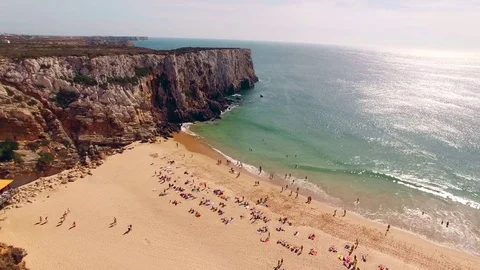 Beautiful cliffs and sandy beach with resting people in Portugal, Praia do Stock Footage 81121099