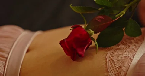 Beautiful close up of a red rose rubbing the belly of an attractive woman Stock-Footage 279529273