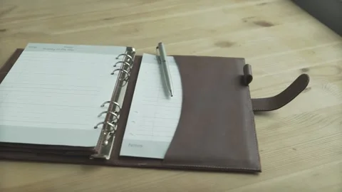 Beautiful close up shot open elegant light brown leather case note pad book dail Stock Footage 137539034