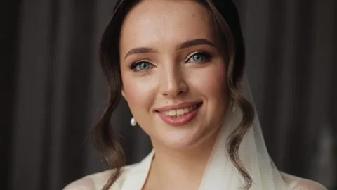 A beautiful close-up shot of a smiling bride on her wedding day. Her blue eyes Stock Footage 286365853