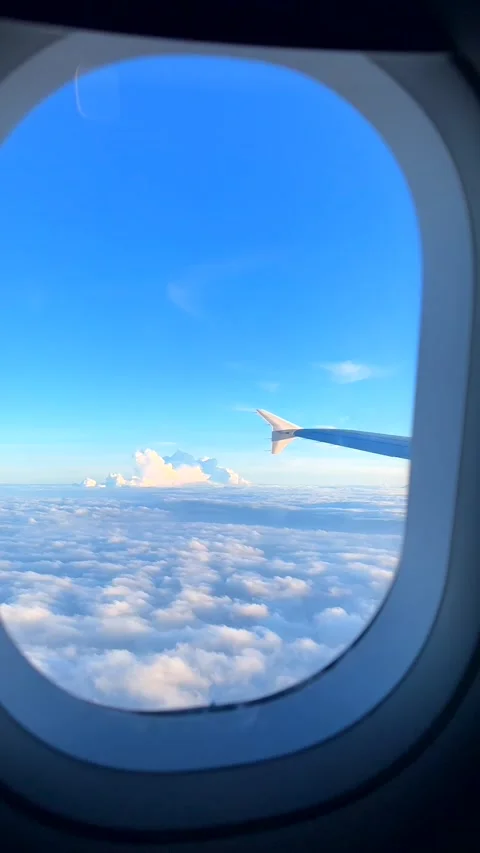 Beautiful cloud and wing of airplane from window with a nice blue sky Stock Footage 338012117