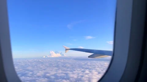 Beautiful cloud and wing of airplane from window with a nice blue sky Stock Footage 338014029