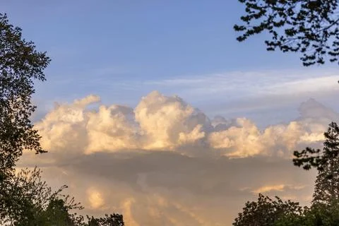 Beautiful cloud formations at sunset framed by trees Stock Photos