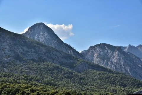 Beautiful cloud over the peaks of the Taurus mountains covered with green Stock Photos