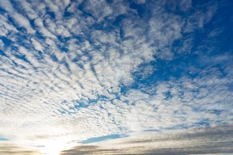 Beautiful cloud patterns in a bright blue sky at sunset time Stock Photos