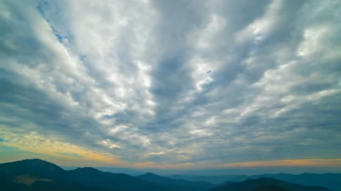 The beautiful cloud stream with a sunset above mountains. time lapse Stock-Footage 97388929