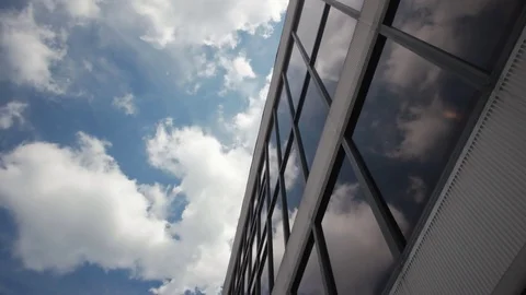 Beautiful clouds and blue sky reflected in the mirrored windows of a corporate Stock-Footage 85366244
