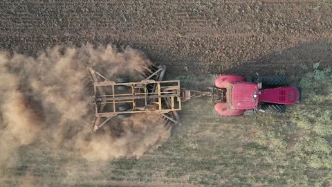 Beautiful clouds of dust - Red tractor plows a the field Stock Footage 167100120