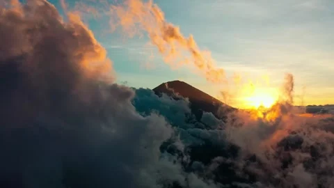 Beautiful Clouds Floating Around Mountain Peak During Golden Sunrise Video stock 330762798