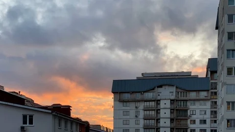 Beautiful clouds flying over roofs in the sky before sunset. Timelapse Stock Footage 125012106