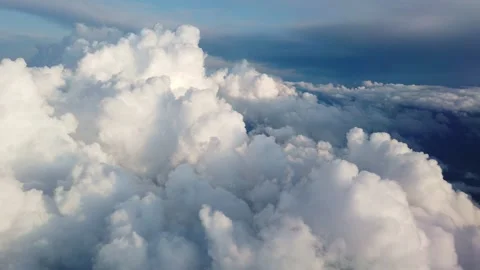 Beautiful clouds illuminated by soft sunlight floating above land and forming Stock Footage 133790827