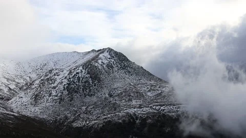 Beautiful clouds moving over a snowy mountain timelapse Stock Footage 130458546