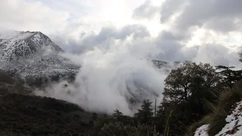 Beautiful clouds moving over a snowy mountain timelapse Stock Footage 130458763