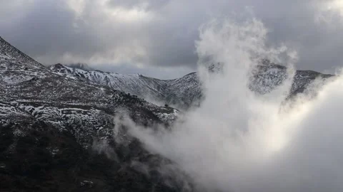 Beautiful clouds moving over a snowy mountain timelapse Stock Footage 130458904