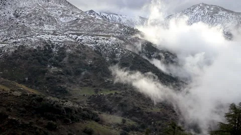 Beautiful clouds moving over a snowy mountain timelapse Stock Footage 130458931