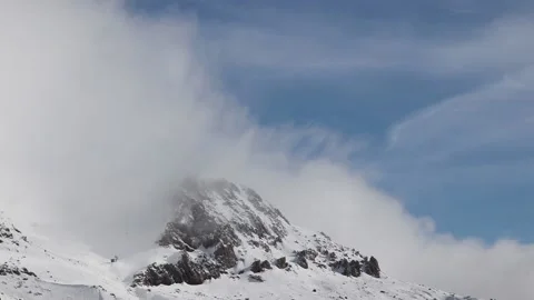 Beautiful clouds moving over a snowy mountain timelapse Stock Footage 130460043