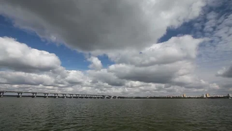 Beautiful clouds over the bridge across the river. Clouds over the river. Stock Footage 155923619