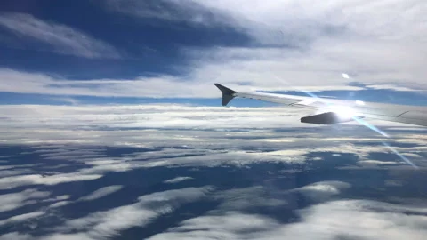 Beautiful Clouds &amp; Sun Flare from an Airplane Window Stock-Footage 147415696