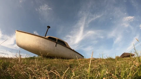 Beautiful clouds time-lapse with old yatch ashore Stock Footage 127357010