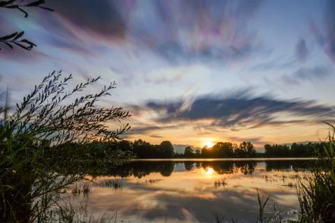 Beautiful cloudscape and sunset breaking through cloud over lake reflection. god Stock Photos
