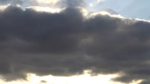 Beautiful cloudscape with large clouds and sunrise breaking through cloud mass Stock Footage 81874914