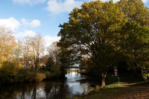 A beautiful cloudscape over a calm Ems canal with a narrow bridge walkway in  Stock Photos