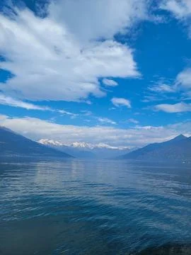 Beautiful cloudscape over Lake Como with mountains, a blue lake, and a fluffy Stock Photos