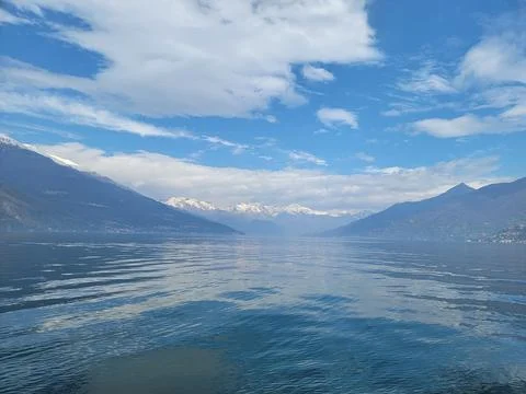 Beautiful cloudscape over Lake Como with mountains, a blue lake, and a fluffy Stock Photos