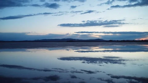 Beautiful cloudy sky at sunset with a mirror image on the surface of the water. Stock Footage 304944836