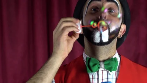 A beautiful clown blows soap bubbles Stock-Footage 85173572
