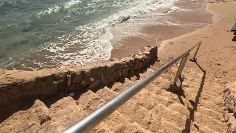 A beautiful coastal scene featuring a pathway leading down to the beach, adorned Stock Footage 330183262