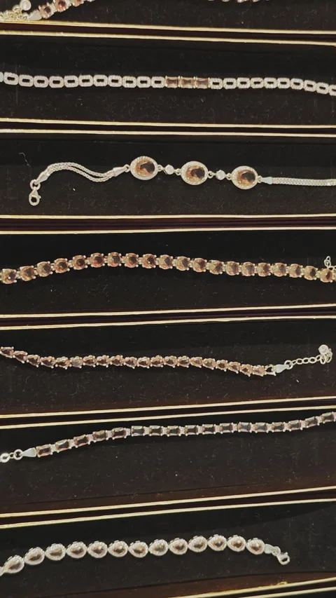 Beautiful collection of elegant silver and golden bracelets with precious brown Video stock 342611120