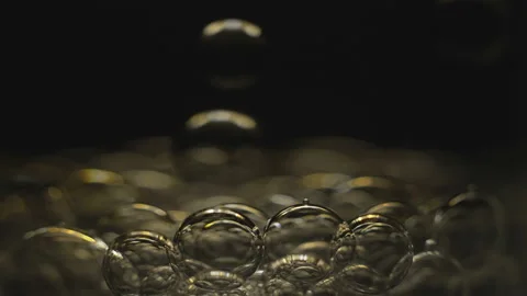Beautiful colored bubbles in a liquid on a black background. Close-up. Stock Footage 97846516