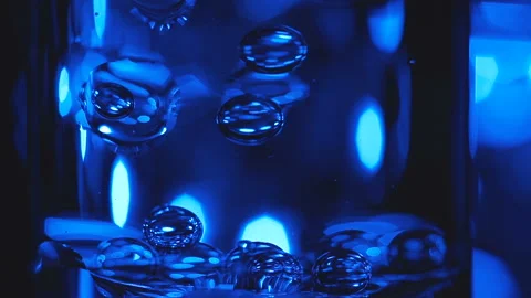 Beautiful colored bubbles in a liquid on a black background. Close-up. Slow Video stock 97847612