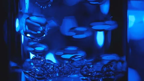 Beautiful colored bubbles in a liquid on a black background. Close-up. Slow Stock Footage 97847644